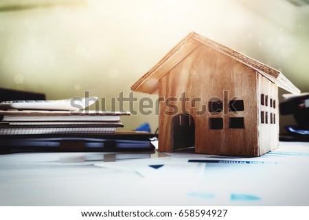 House and property for sale concept, wood house toy on office desk.