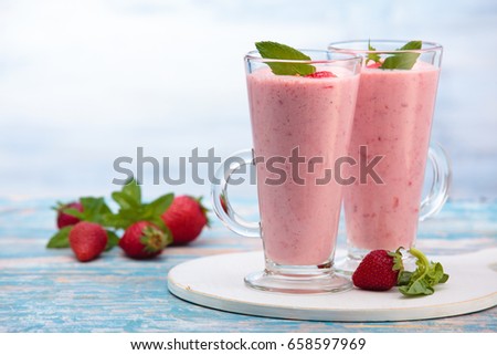 Strawberry smoothie with mint leaves on wooden rustic table.
