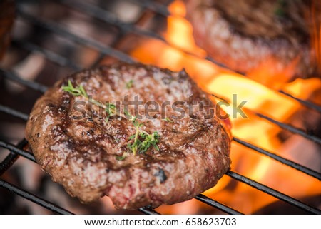 close up burger on bbq over flames