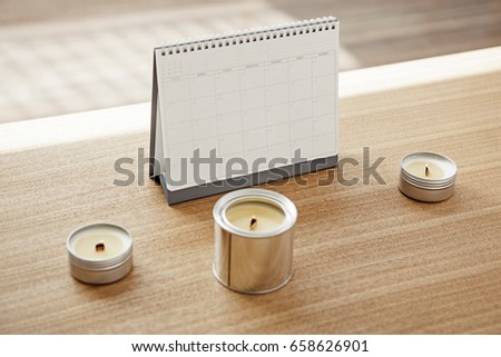 A desk calendar with candle can on the wood table(desk)