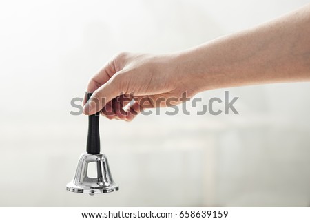 A man hand hold a bell.