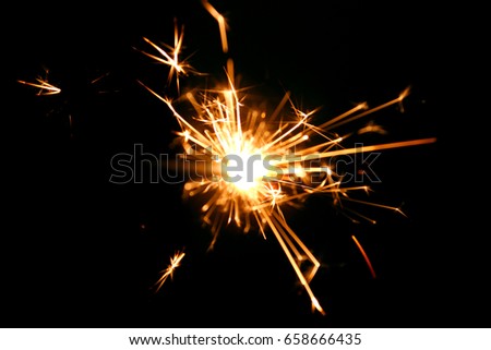 sparkler background / A sparkler is a type of hand-held firework that burns slowly while emitting colored flames, sparks, and other effects