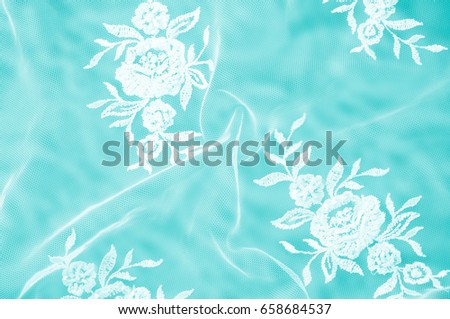 Texture, background, pattern. Lacy white fabric. Flowers made of lace fabric. Blue background of silk fabric. greeting card. Wallpaper for your desktop. Screensaver backdrop for designer