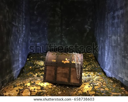 A vintage wood treasure box with shinny gold metal and golden coin found in old mystery cave. 