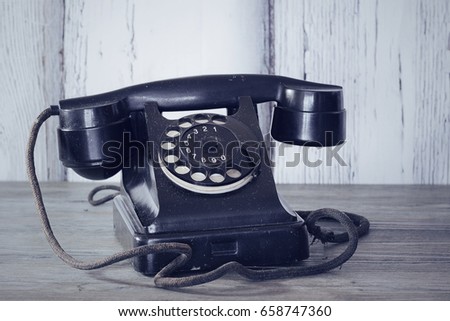 Vintage telephone on old table. Horizontal. Soft focus. Toning.