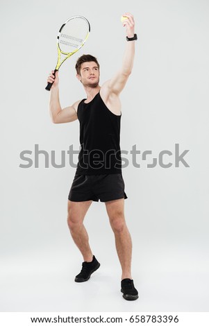 Picture of concentrated young sportsman playing tennis isolated over white background.
