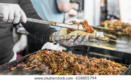 Chef at a street food market preparing a taco