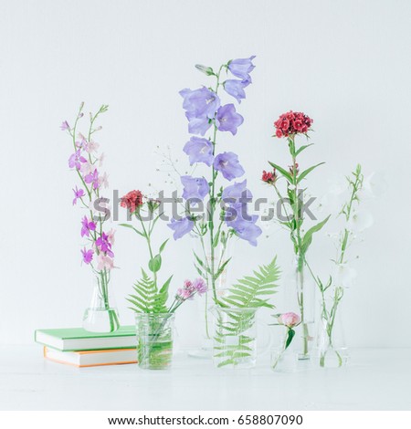 Beautiful composition with perfume samples and flowers on table. Flowers in flasks. Wildflowers. Summer bouquet.