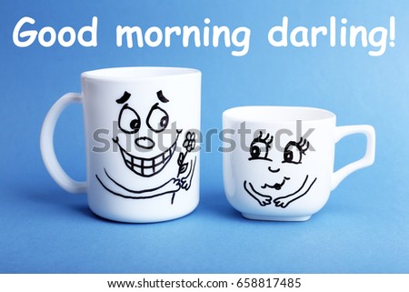 Text GOOD MORNING DARLING and cups with funny faces on color background