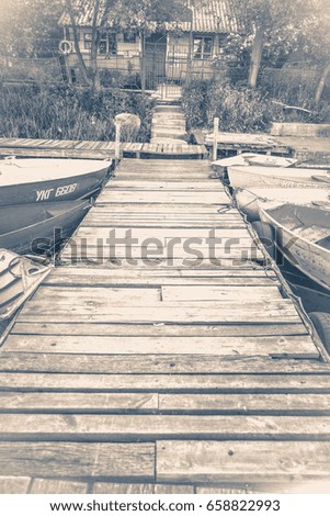 Old vintage photo. Old wooden pier and several boats