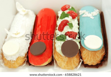 Baking in the form of tubes with fruit cream, decorated with strawberries and confectionery icing
