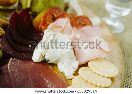 Starter plate with sliced salami and assorted cheese and roast