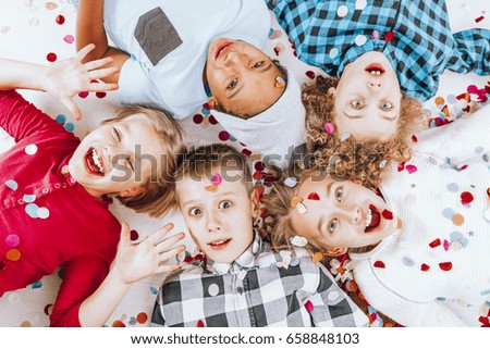Happy little kids lying together on the ground