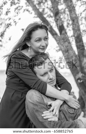 Affectionate young couple in park by the river. Love story. Black and white.