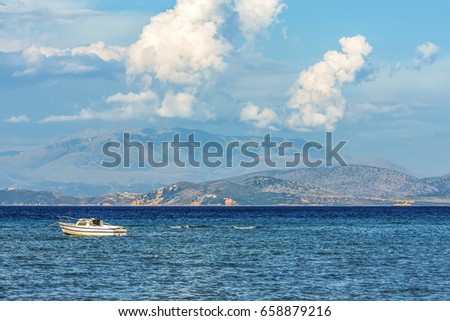 Boat waving in the Ionian sea near Corfu island, Greece. Mountains at the background.