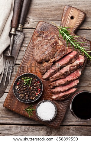 Grilled beef steak with spices on cutting board. Top view