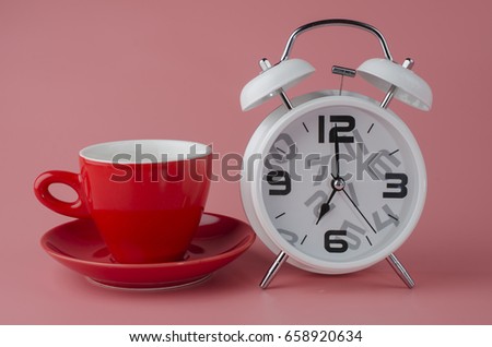 white alarm Clock and red cup on pastel background. with free copyspace for your creativity ideas text