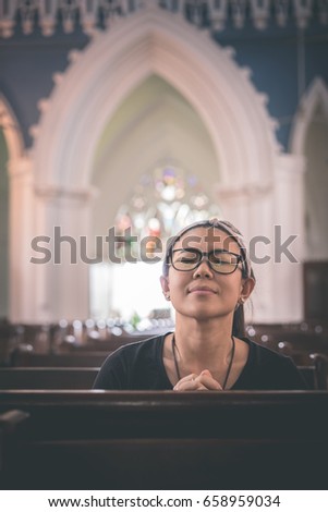 A girl is praying in the church.