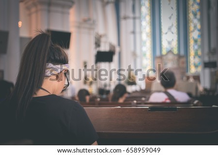 A girl is praying in the church.