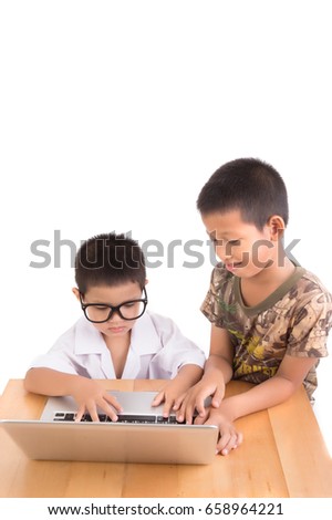 Older brother is helping his little brother use computer laptop, Two asian boys sharing their laptop on wooden table on white background, knowledge concept.
