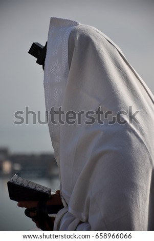 Religious Jewish man pray the jewish prayer  "Shema Israel" - hear our prayer our lord -with tefillin and a Tallis (Tallit), Jewish culture &Symbols, religion, Torah, Israel Royalty-Free Stock Photo #658966066