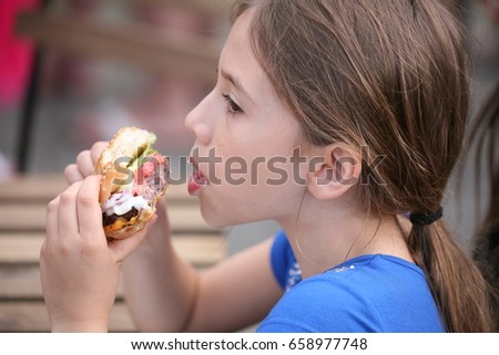 young girl eating hamburger