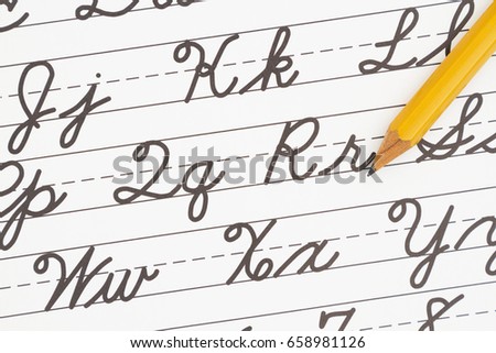 Learning to write cursive lettering, Samples of cursive lettering on lined paper with a pencil Royalty-Free Stock Photo #658981126