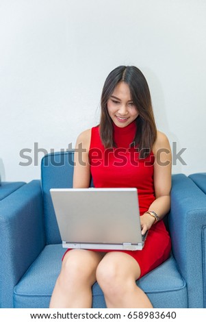 Business girl in red dress sit on sofa for work on laptop,business woman work in office concept