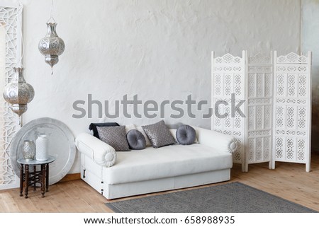 Eastern traditional interior. Morocco style room. Arch and window with beautiful carving. White and gray room with beautiful white sofa and pillows Royalty-Free Stock Photo #658988935