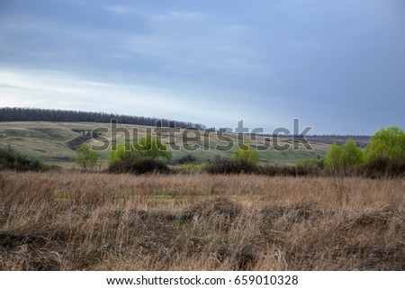 Day landscape Russian nature. Spring fields on the overcast sky backgroung.