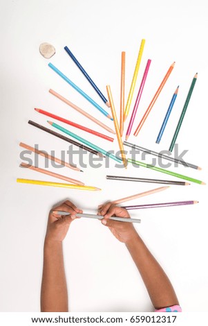 Little girl showing pencils in rainbow colors - education concept
Back To School