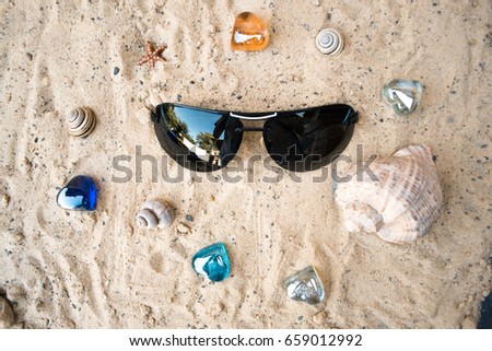Black sunglasses on the beach in the sand
