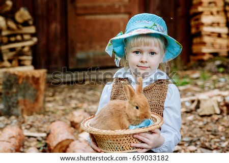 the girl in the blue skirt, holding a rabbit on his hands
