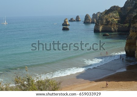 Natural beauty of the sandy beach on Algarvian coastline, Portugal. Sunny travel vacation relaxing outdoors background. Blue sky peaceful seascape view