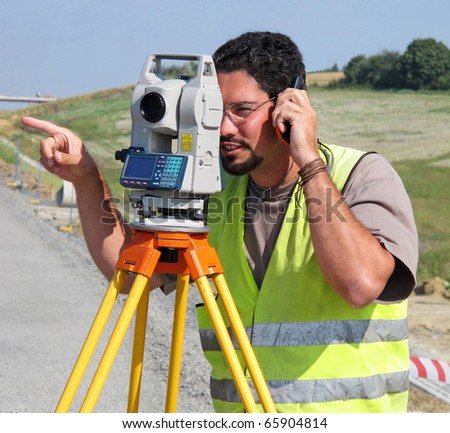 Surveyor with theodolite showing a direction
