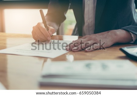 Close-up Of Businessman Signing Contract Paper With Pen, vintage filter effect