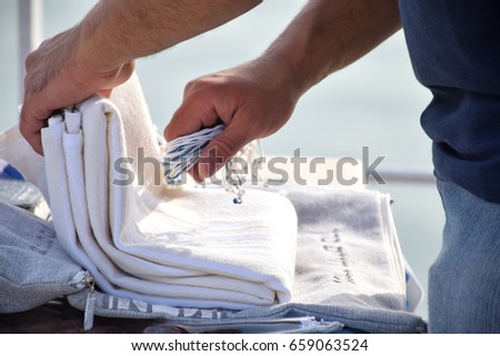 Shema Israel - hear our prayer our lord, Religious Jewish man praying, holding the Tzitzit (tsitsit) of the Shawl - Talis (Tallit), a Jewish symbol and folding it into the talis's bag. Royalty-Free Stock Photo #659063524