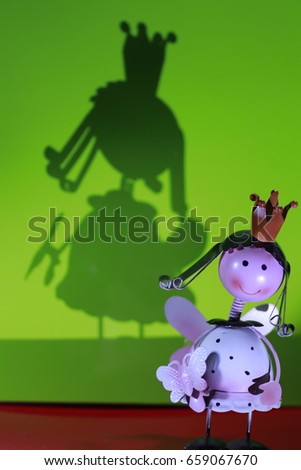 the little girl queen doll and shadow on green background
