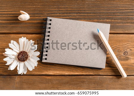Blank notebook with flower on vintage wooden table