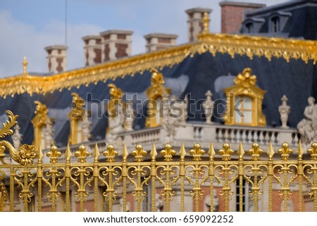 Versailles chateau. France. View of golden gate to palace. Royal residence near Paris. King's quarters. Famous touristic renaissance architecture landmark in summer. Toned