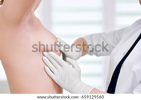 Cropped close up of a doctor examining breast of her female patient cancer awareness prevention checkup healthcare feminine medicine clinical concept. Royalty-Free Stock Photo #659129560