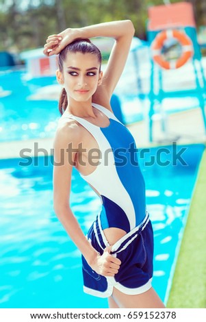 Young model girl posing near pool