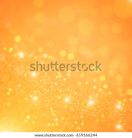Bright and abstract blurred orange  bokeh background with shimmering glitter.
