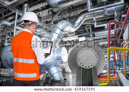 Engineer using laptop computer for maintenance in thermal power plant factory