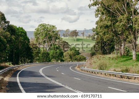 Beautiful Australian road crossing a green landscape.