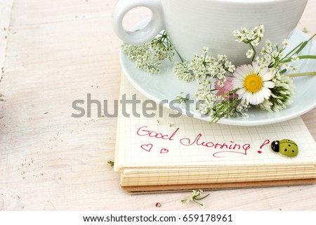 Paper notebook with handwritten text: Good morning. Concept for romantic and love theme. Eco decor and pure white color
