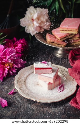 Fruit cakes taffy (lucum) and sand cakes on a dark background, decorated with peonies. Summer light and delicious dessert. Close up