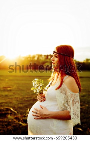 pregnant redhead girl at sunset