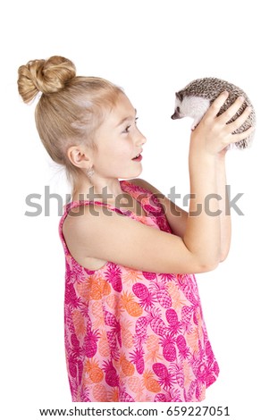 A young girl holding a hedgehog on an isolated white background