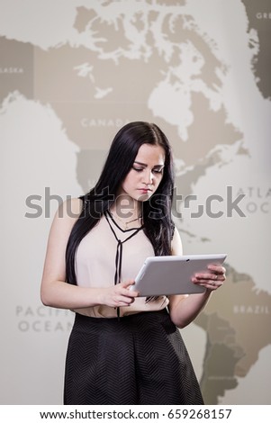 Image of businesswoman holding a digital tablet and looking at it close up